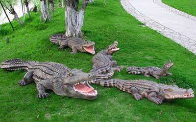 公園草地上擺放的形態各異的玻璃鋼仿真動物鱷魚雕塑